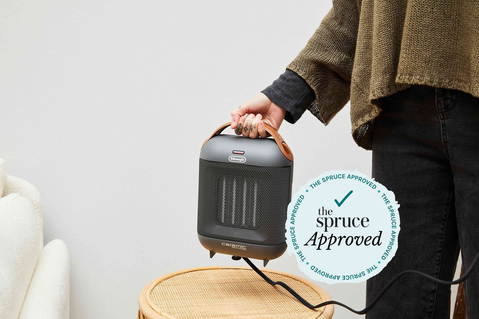 A modern compact heater provides warmth in a cozy, minimalist living room setting.
