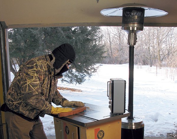 A modern heater provides efficient warmth for a professional woodworking shop workspace.