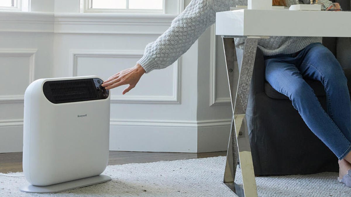 A modern ceramic space heater warming a cozy living room during a cold day.