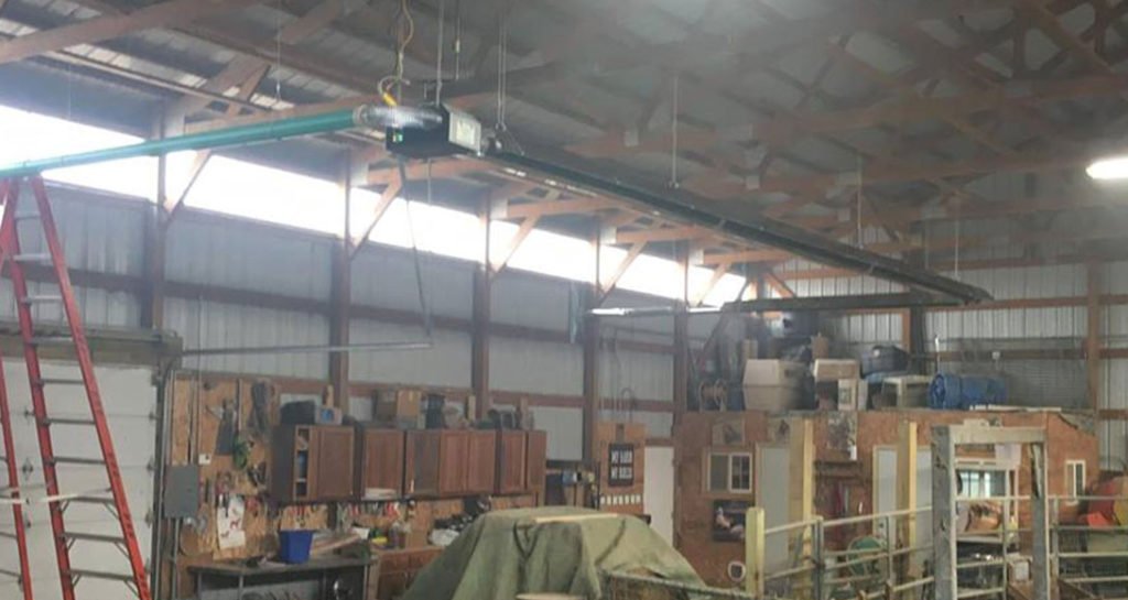 A modern radiant heater installed in a spacious 40x60 industrial workshop environment.